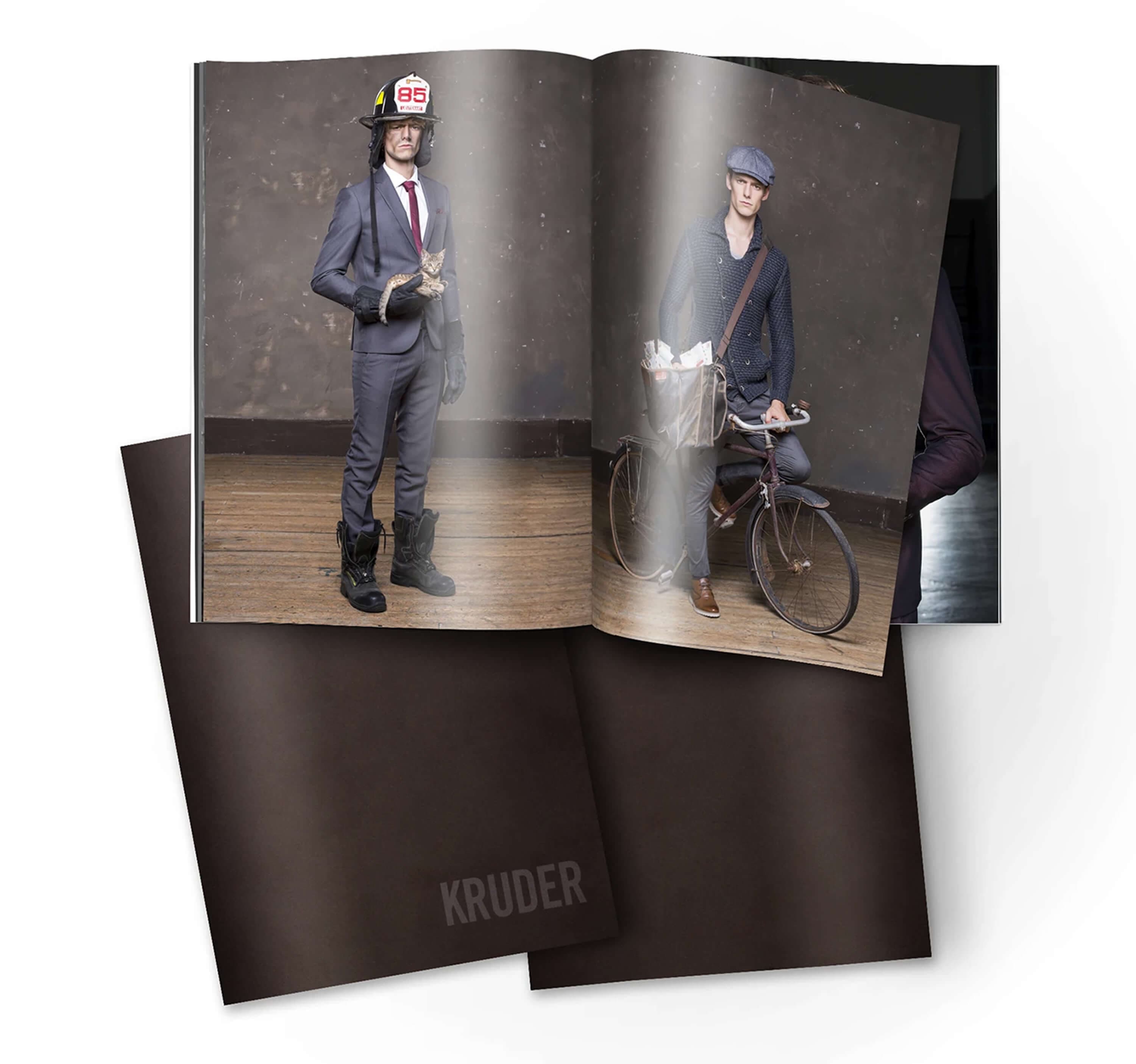The printed lookbook — the magazine open on the firefighter and postman shots, resting on a second copy with the Kruder logo embossed on the brown cover