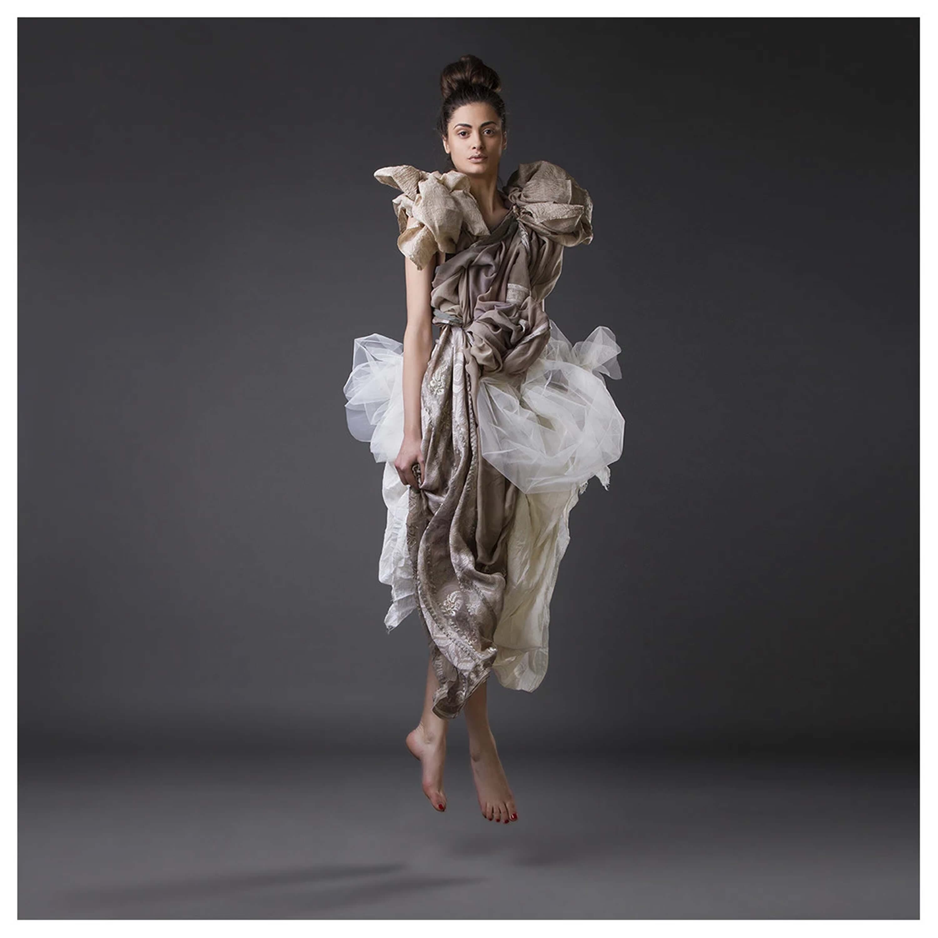 The same look in mid-air, barefoot, the tulle and the embroidered silk lifted by the jump