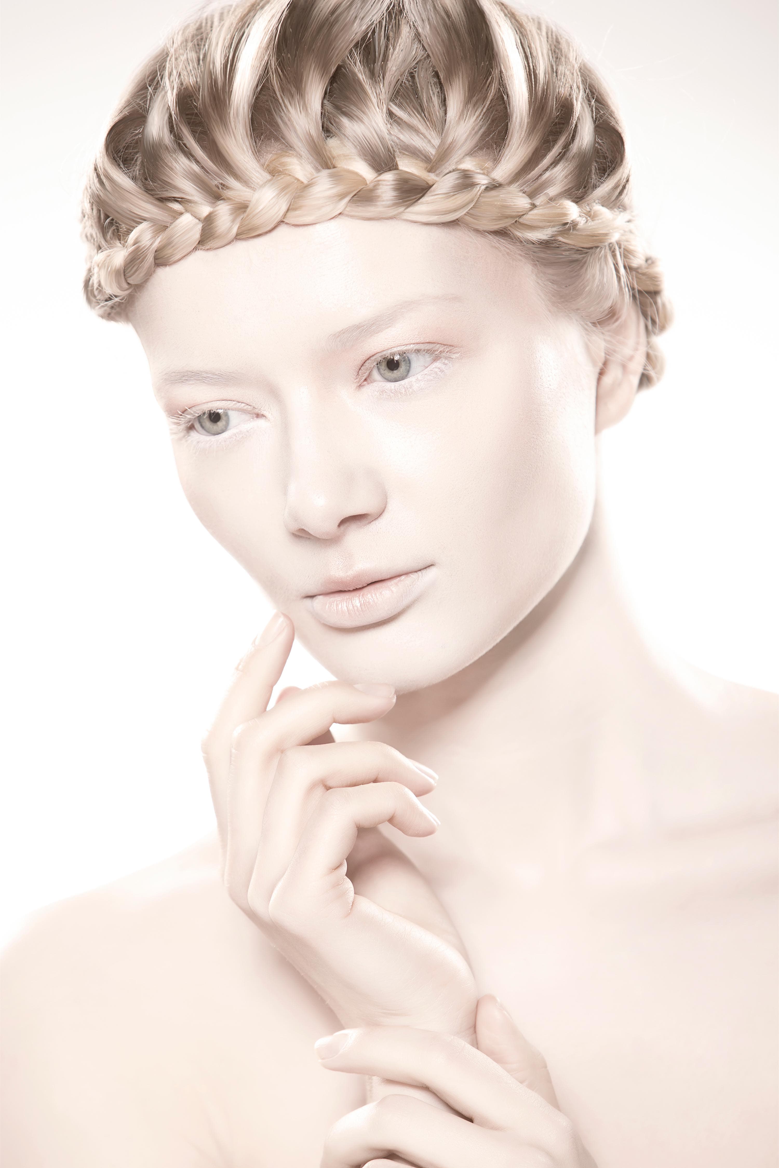 Front beauty portrait — crown braid, hand raised to the chin, on white