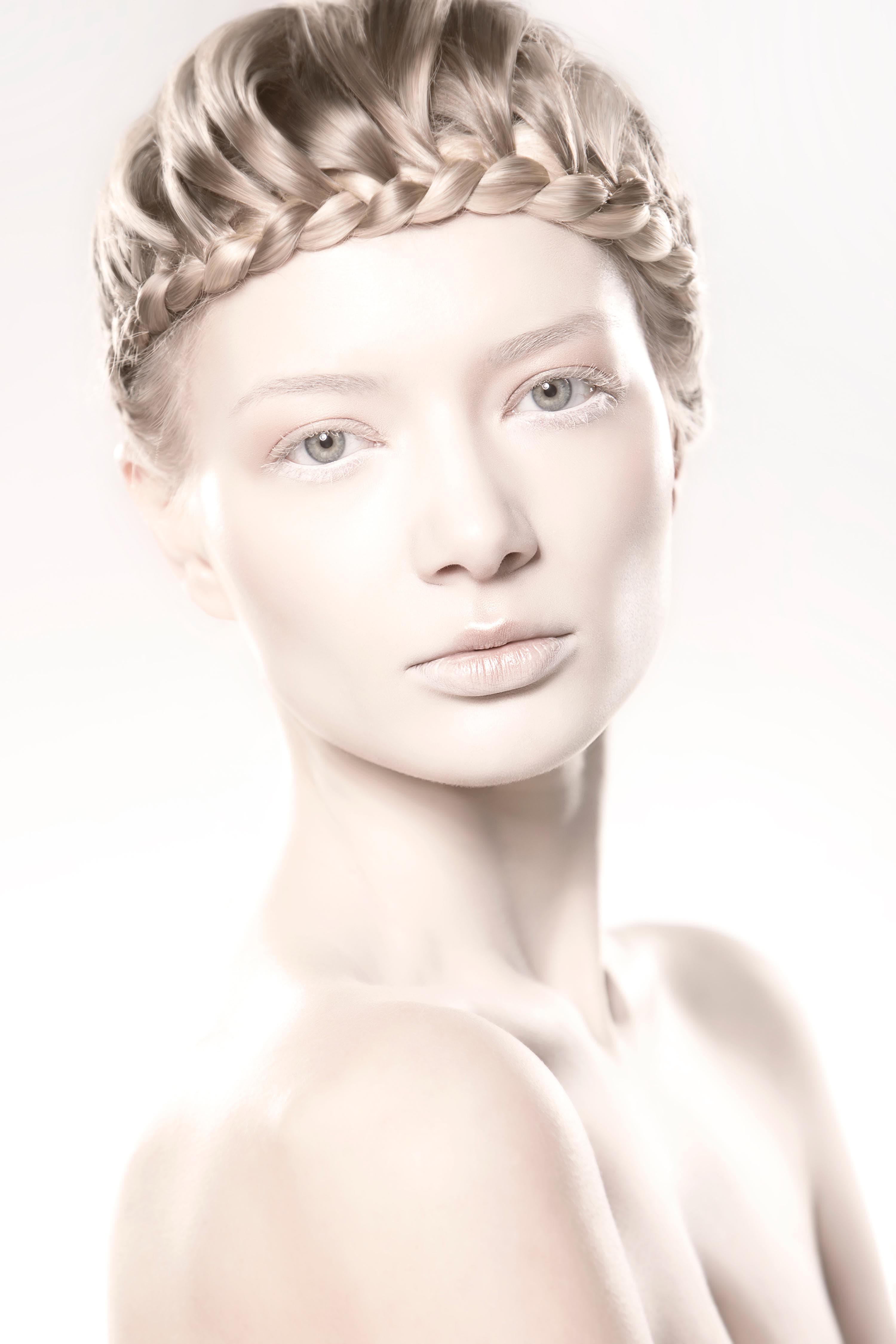 Three-quarter beauty portrait — crown braid, bare shoulders, on white