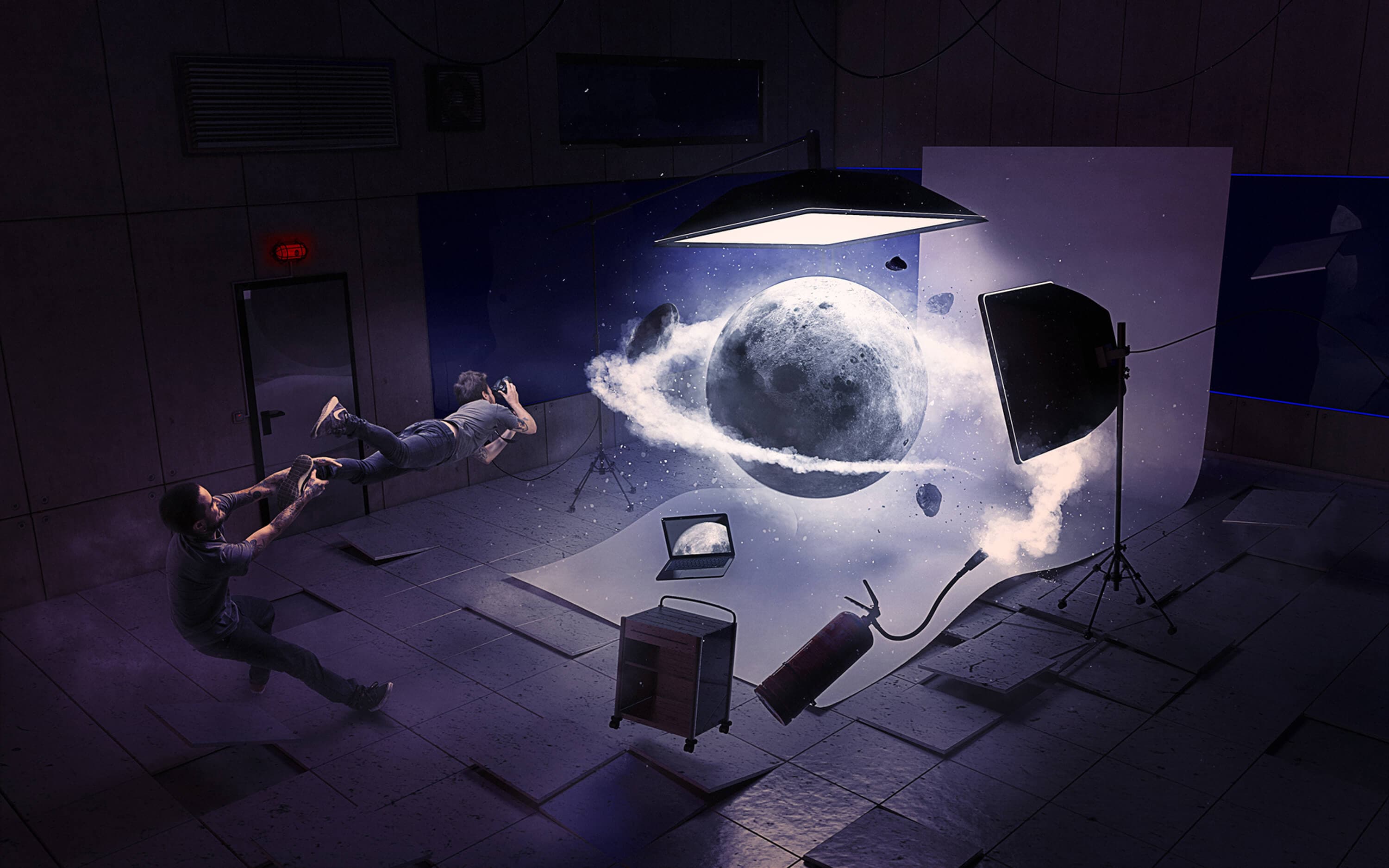 The Moon, the finished image — the full moon hanging in the studio wrapped in a ring of vapour, one photographer flying horizontally in mid-air holding his camera while a colleague grabs his ankle, a fire extinguisher spinning loose across the floor beside the laptop and the trolley